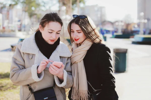 人の女性は 社会的なネットワークでの携帯電話で写真を見る — ストック写真