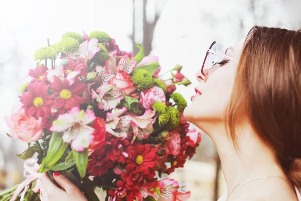 美丽的年轻女子与一大束鲜花在公园里 — 图库照片