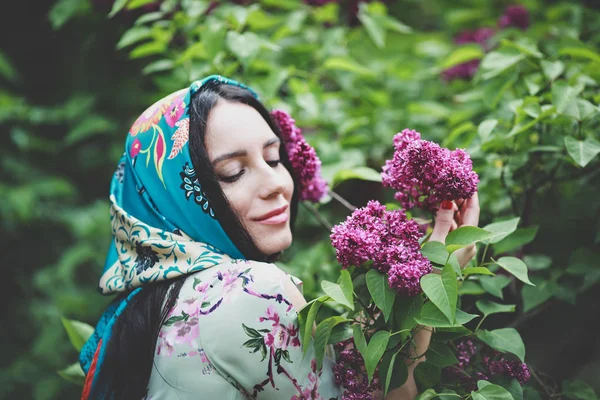 美しい女性は花ライラックの木を嗅ぎます — ストック写真