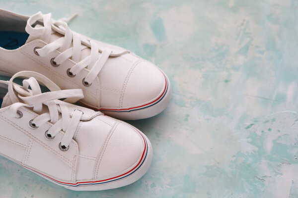 красивые белые кроссовки на светлом фоне в студии
