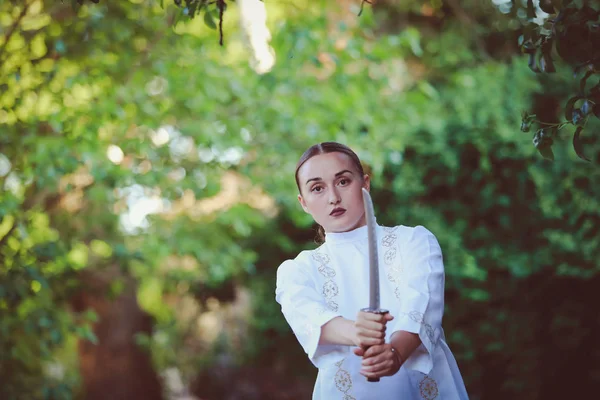 bir kılıç ile beyaz elbiseli güzel genç kadın