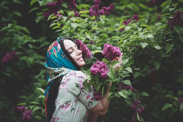 美しい女性は花ライラックの木を嗅ぎます — ストック写真