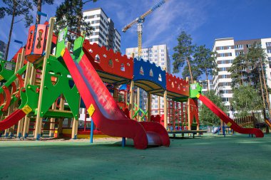 yüksek katlı binalar arasındaki parkta çocuklar için çok renkli oyun alanı