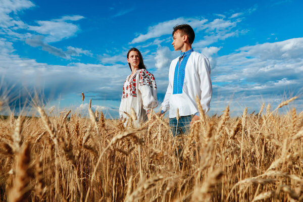 boy and girl on a wheat field in embroidered clothes
