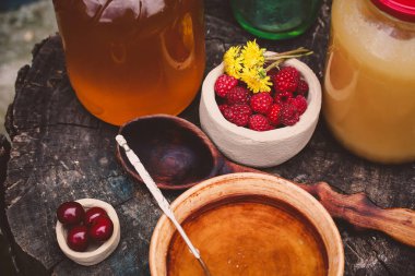 ahşap bir masada güzel bir çanak ahududu ve bal