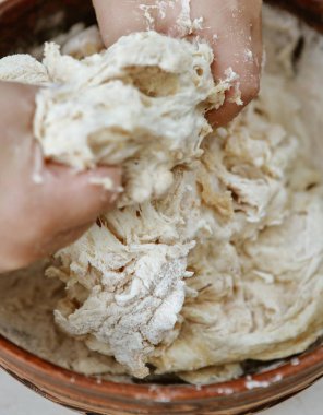 bebek elleri bir pizza tabağı içinde hamur yoğurun