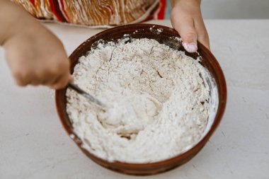 bebek elleri bir pizza tabağı içinde hamur yoğurun