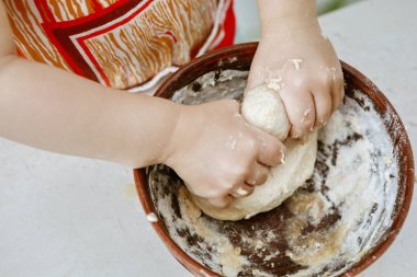 bebek elleri bir pizza tabağı içinde hamur yoğurun