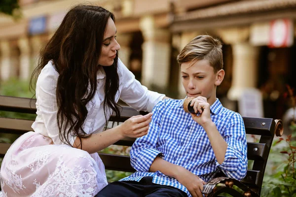 mother and son eat ice cream on the bench and have fun