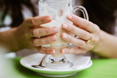 bir restoranda bir saman gelen latte içme kadın