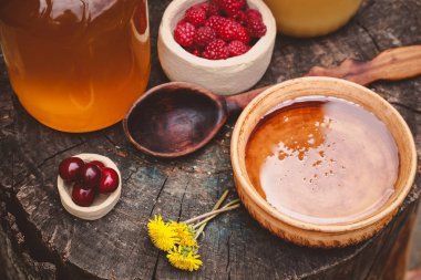 ahşap bir masada güzel bir çanak ahududu ve bal