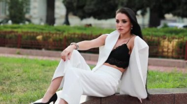 bir bankta oturan bir takım elbise zarif güzel kadın