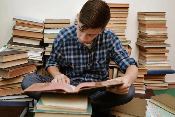 guy in a plaid shirt is studying old books