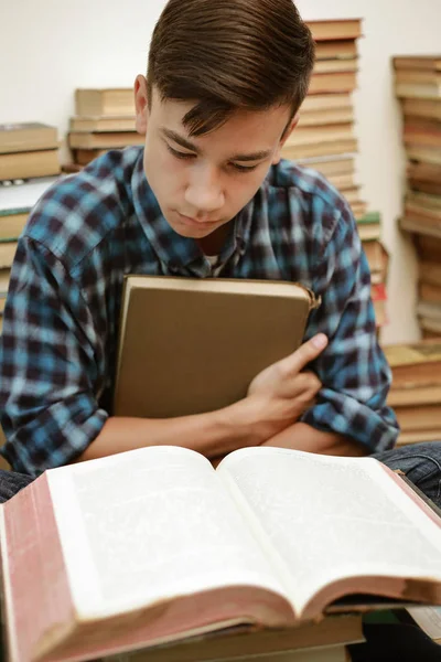guy in a plaid shirt is studying old books