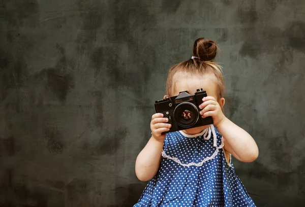 little girl in a beautiful dress learn to take pictures