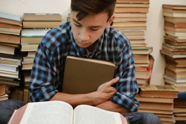 guy in a plaid shirt is studying old books