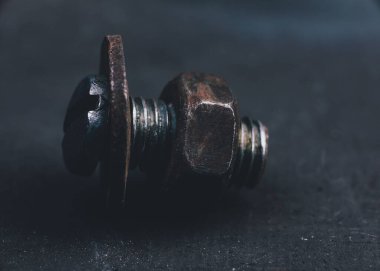 Karanlık bir arka planda cıvata ve fındık