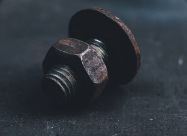 Karanlık bir arka planda cıvata ve fındık