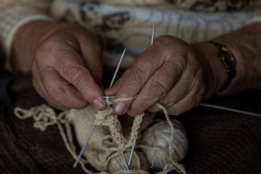 Büyükanne hafif bir eşarp örüyor.