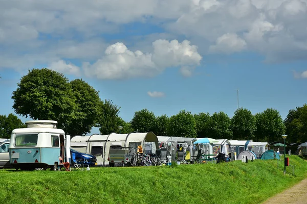 Vintage travel trailer in a row of tents on a campsite in Limburg, The Netherlands.