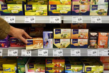 Almanya - Ekim 2018: ürün yelpazesine aromalı çay ambalajlar Messmer marka çay kartonları içeren bir Rewe süpermarkette.