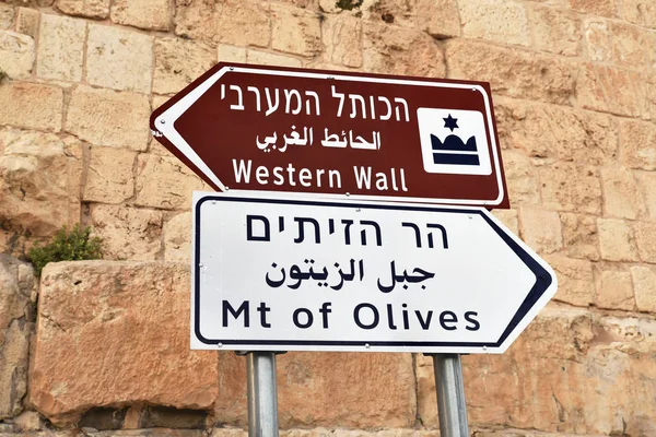 Direction sign to Jerusalem Old City, Western Wall, Mount of Olives. Israeli road sign in three languages leads to tourist places in Jerusalem.