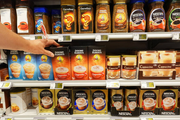BELGIUM - JULY 2019: Shelves filled with different brands instant coffee products in a Carrefour supermarket.