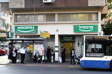 BNEI BRAK, ISRAEL - Aralık 2019: Haham Akiva Caddesi 'ndeki otobüs durağında Hasidik insanlar bekliyor.