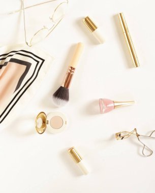 Güzel kadın aksesuar çanta, ipek mendil, Gözlük, izle, bilezik ve beyaz zemin üzerine hafifçe pastel bej tonlarında kozmetik.