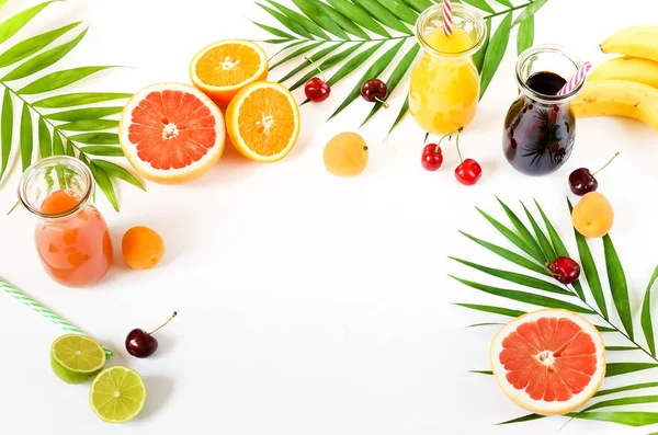 ガラスの瓶オレンジ グレープ フルーツ さくらんぼと白い背景にさまざまな果物の天然ジュースの品揃え 平面図です コピー スペース — ストック写真