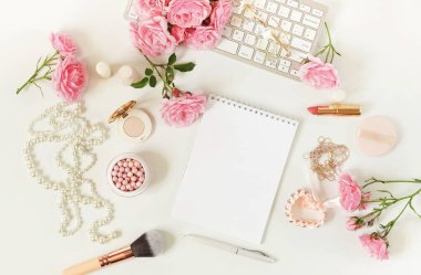 Düz lay, üstten görünüm office kadınsı Danışma, kadın aksesuarları, makyaj laptop ve buket gül ile çalışma alanı. Güzellik blog kavramı. Kopya alanı