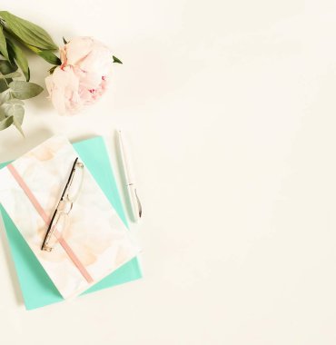 Lay kadın ofis masası düz. Çiçekler peonies, aksesuarlar, defter, beyaz zemin üzerine gözlük ile kadın çalışma alanı. Üstten görünüm kadınsı arka plan. Kopya alanı