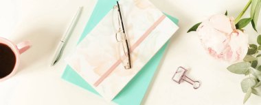 Lay kadın ofis masası düz. Kadın çalışma alanıyla çiçek peonies, aksesuarlar, defter, Gözlük, beyaz arka plan üzerinde kahve. Üstten görünüm kadınsı arka plan. Uzay kopyalayın. afiş