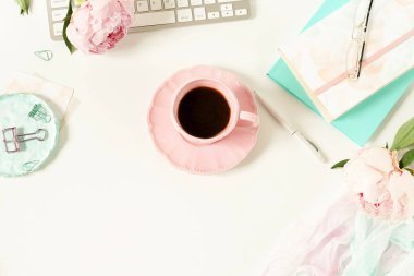 Lay kadın ofis masası düz. Kadın çalışma alanıyla laptop, çiçek peonies, aksesuarlar, defter, Gözlük, beyaz arka plan üzerinde kahve. Üstten görünüm kadınsı arka plan. Kopya alanı