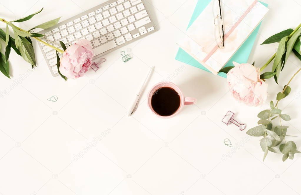 Flat lay women's office desk. Female workspace with laptop,  flowers peonies,  accessories, notebook, glasses, cup of coffee on white background. Top view feminine background.Copy space