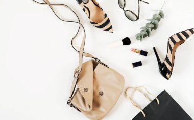 Düz yatıyordu, en iyi kadın moda aksesuarları görünümünü. Bej çanta, güneş gözlüğü, yüksek topuk ayakkabı ve beyaz arka plan üzerinde kozmetik. Kopya alanı