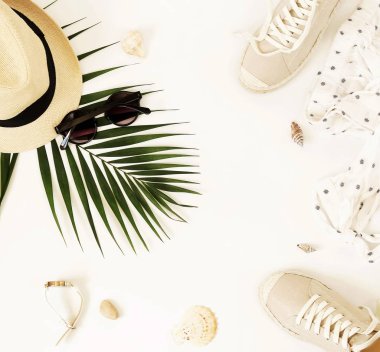 Moda arka plan. Kadın yaz giyim ve aksesuar kolaj beyaz arka plan üzerinde seyahat. Hasır şapka, spor ayakkabı espadrill, güneş gözlüğü, çanta, bluz ve palmiye yaprağı. Üstten görünüm, düz yatıyordu.