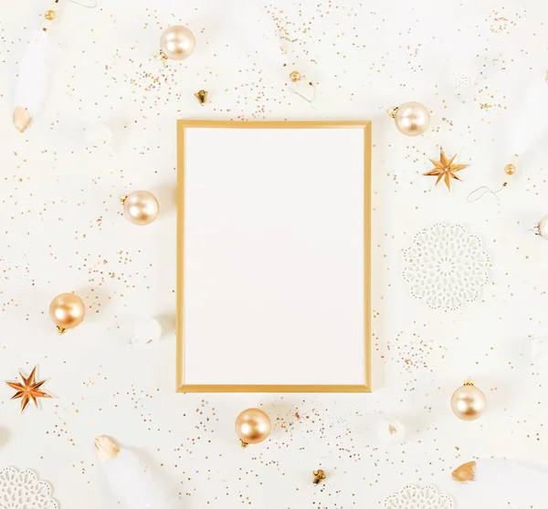 Christmas background from gold and white Christmas decorations and frame mock up . Xmas composition of New Year\'s Christmas balls. Winter holiday concept.Flat lay. Top view. Copy space