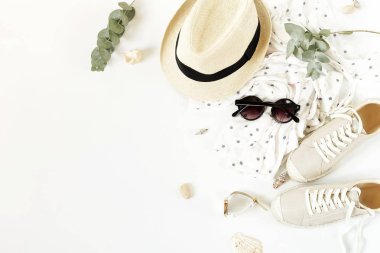 Moda arka plan. Kadın yaz giyim ve aksesuar kolaj beyaz arka plan üzerinde seyahat. Hasır şapka, spor ayakkabı espadrill, güneş gözlüğü, çanta, bluz ve palmiye yaprağı. Üstten görünüm, düz yatıyordu.