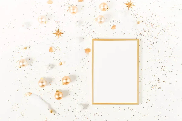 Christmas background from gold and white Christmas decorations and frame mock up  . Xmas composition of New Year\'s Christmas balls. Winter holiday concept.Flat lay. Top view. Copy space