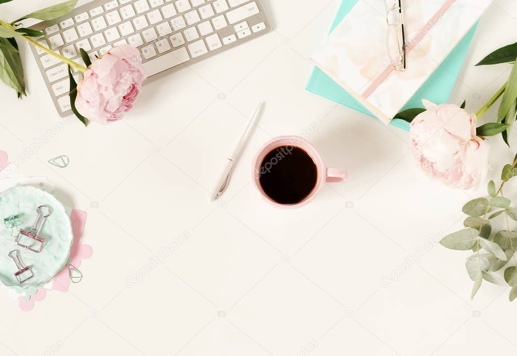 Flat lay women's office desk. Female workspace with laptop, flowers peonies, accessories, notebook, glasses, cup of coffee on white background. Top view feminine background.Copy space