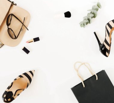 Düz yatıyordu, en iyi kadın moda aksesuarları görünümünü. Bej çanta, güneş gözlüğü, yüksek topuk ayakkabı ve beyaz arka plan üzerinde kozmetik. Kopya alanı