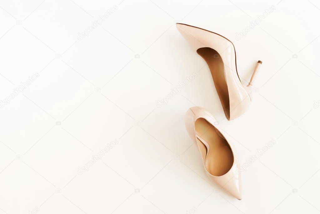 Fashion background. women high heel shoes in beige color on white background. Fashion blog look. Flat lay, top view trendy beauty female background. High heels background.Copy space