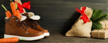 Hollanda tatil Sinterklaas arka plan. Çocuk ayakkabı, havuç, kahverengi ahşap zemin üzerinde hediyeler. Kopya alanı