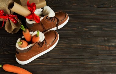 Hollanda tatil Sinterklaas arka plan. Çocuk ayakkabı, havuç, kahverengi ahşap zemin üzerinde hediyeler. Kopya alanı