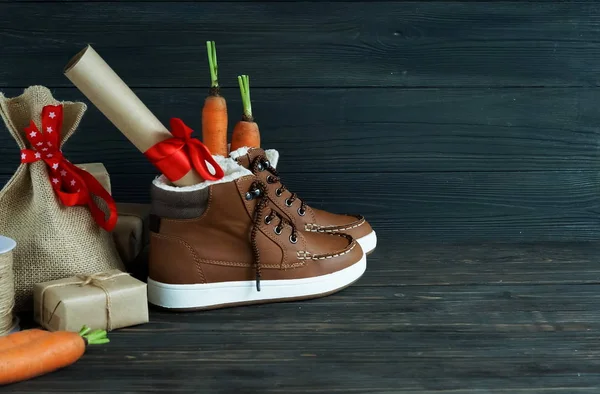 Hollanda tatil Sinterklaas arka plan. Çocuk ayakkabı, havuç, kahverengi ahşap zemin üzerinde hediyeler. Kopya alanı