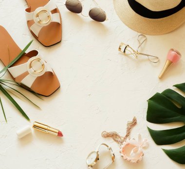 Kadının yaz moda seyahat aksesuarları en iyi görünümü arka plan sandalet, hasır şapka, Ayakkabı tropikal yaprak, güneş gözlüğü, aksesuar beyaz arka plan üzerinde makyaj. Yaz konsepti. Düz yatıyordu. 