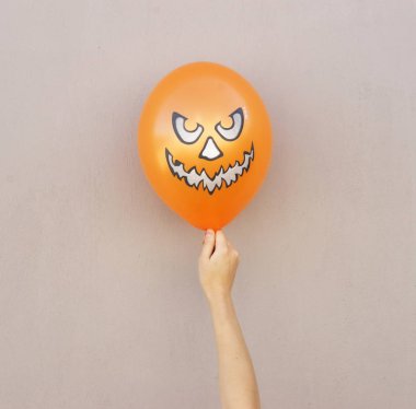 Cadılar Bayramı en az kavramı arka plan. portakal kız balonunda el duvar arka plan üzerinde. Düz yatıyordu, en iyi görünümü.