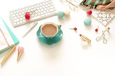 Lay kadın ofis masası düz. Dizüstü bilgisayar, çiçek gül, aksesuarlar, dizüstü bilgisayarlar, Gözlük, kahve ve beyaz arka plan üzerinde kozmetik birlikte kadın çalışma alanı. Üstten görünüm kadınsı arka plan. Kopya alanı. 