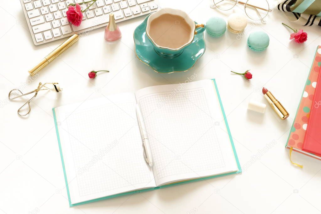 Flat lay women's office desk. Female workspace with laptop,  flowers roses,  accessories, notebooks, glasses, cup of coffee, cosmetics on white background. Top view feminine background.Copy space. 